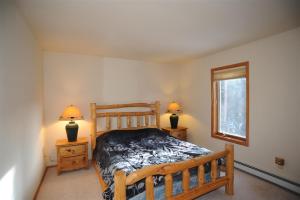 a bedroom with a wooden bed and two night stands at 72 Clubhouse in Breckenridge