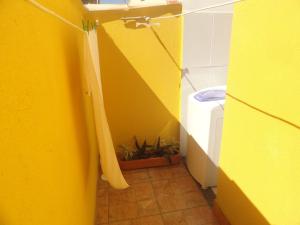 un bagno giallo con servizi igienici e parete gialla di LA DORITA a Búzios Altre 10 foto