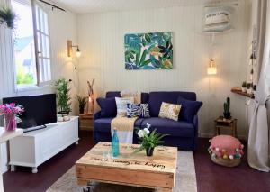 a living room with a blue couch and a coffee table at Le Belvédère in Bénerville-sur-Mer