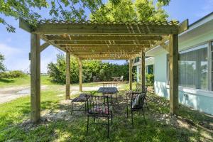 una mesa de picnic bajo una pérgola de madera en una casa en Charming Waterfront Cabin Cabin, en Norfolk