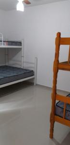 una habitación con una litera y una silla de madera en Conjunto Residencial Verdes Mares, en Guaratuba