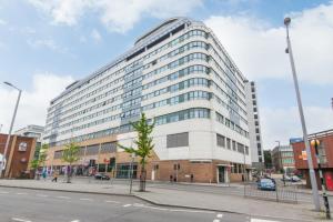 a large building on a city street with a street at Marco Island -Spacious City Centre 2 Bedroom Apartment in Nottingham