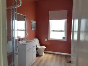 a bathroom with a toilet and a sink and a window at Kumara Historic Cottages in Kumara +43 photos