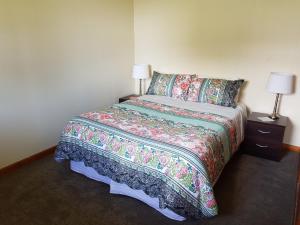 A bed or beds in a room at Kumara Historic Cottages
