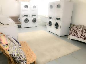 a laundry room with three washing machines and a couch at Casa Bonita Apartments in Long Beach