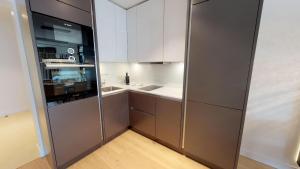 ティメンドルファー・シュトラントにあるWhite Pearl Apartment 2.03の白いキャビネットと大型冷蔵庫付きのキッチンが備わります。
