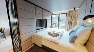 - une chambre avec un grand lit et une télévision dans l'établissement White Pearl Apartment 2.03, à Timmendorfer Strand