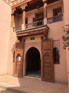 een toegang tot een gebouw met houten deuren bij Palmeraie Charly's in Marrakesh