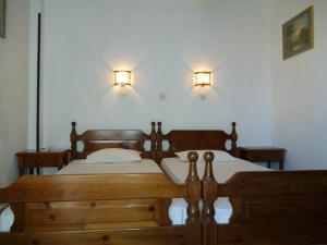 a bedroom with two beds and two lights on the wall at Pension Eleni Rooms in Kokkari