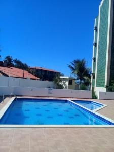 a large swimming pool with two tall buildings at Apartamento na Praia in Fortaleza