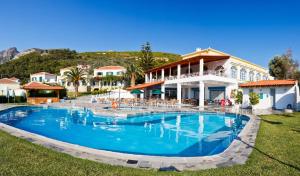 a large swimming pool in front of a house at Arion Hotel in Kokkari