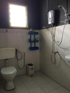 uma casa de banho com um chuveiro, um WC e um lavatório. em Suhana HomeStay Semporna - Cozy Home em Semporna