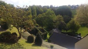 een uitzicht over een tuin met een boom en struiken bij T1 tout équipé avec balcon & parking ! in Cherbourg en Cotentin