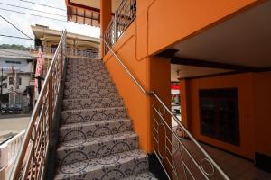 a staircase leading up to a building with orange walls at RedDoorz near Sarangan Lake in Magetan