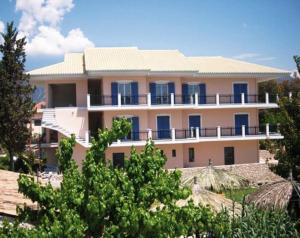 a large building with blue windows and trees at Maistrali in Vasiliki