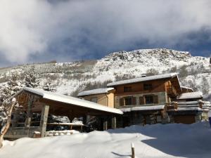 a building covered in snow in front of a mountain at Monster Chalets in Le Bettaix
