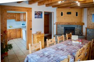 a kitchen and dining room with a table and a fireplace at Monster Chalets in Le Bettaix