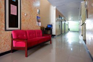um sofá vermelho num corredor de um hospital em RedDoorz near GOR Wisanggeni em Tegal