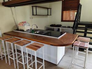 a kitchen with a sink and a counter with stools at De Hanami Homestay @Sapphire in Cirebon