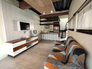 a living room with a couch and a tv at De Hanami Homestay @Sapphire in Cirebon