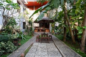 un patio con mesa y sillas en un jardín en RedDoorz Syariah near Menara Kudus en Kudus