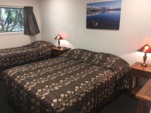 ein Hotelzimmer mit 2 Betten und einem Fenster in der Unterkunft Woodlands Motels And Apartments in Dunedin