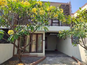 a building with a tree in front of it at De Hanami Homestay @Sapphire in Cirebon