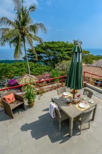 d'une terrasse avec une table et un parasol vert. dans l'établissement Villa Karingal, à Senggigi