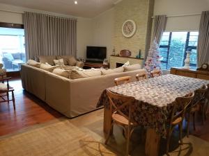 uma sala de estar com um sofá e uma mesa em Bushys Oak em Bushmans River Village