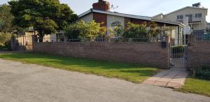 a brick fence in front of a house at Bushys Oak in Bushmans River Village