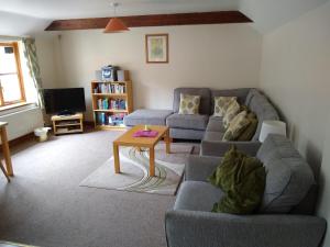 uma sala de estar com um sofá e uma mesa em Swallow cottage em Louth