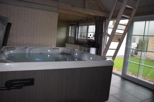 uma grande banheira num quarto com uma cozinha em B&B Jo - Li em Diepenbeek