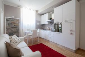 eine weiße Küche mit einem weißen Sofa und einem Tisch in der Unterkunft LEO'S HOME in La Spezia