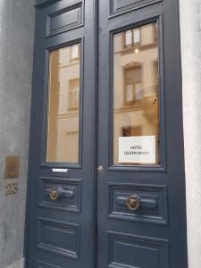Una puerta azul en un edificio con un cartel. en Hotel Queen Mary en Bruselas