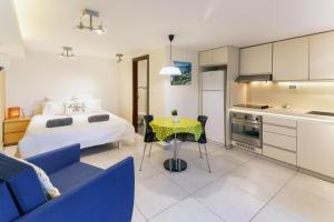 a bedroom with a bed and a table and a kitchen at Quiet Apartments in Beit Safafa- Jerusalem in Jerusalem
