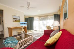 a living room filled with furniture and a couch at Fairway Motor Inn in Merimbula