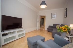 ein Wohnzimmer mit einem großen TV und einem Sofa in der Unterkunft CR Apartament w Centrum Lipowa 18 in Białystok