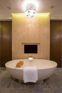 a bath tub in a bathroom with a chandelier at Dusit Thani Guam Resort in Tumon