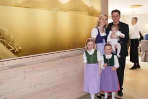 Eine Familie, die für ein Bild vor einem Gemälde posiert. in der Unterkunft Hotel Garni Buchinger in St. Wolfgang