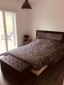 ein Schlafzimmer mit einem Bett und ein Fenster mit einer Terrasse in der Unterkunft Maison en pierre entièrement rénovée. in Trébry + 2 Fotos