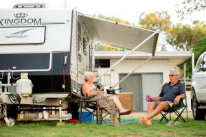 two people sitting in chairs in front of an rv at Banksia Tourist Park in Perth