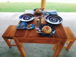 a wooden table with three plates of food on it at Whisky Point Resort in Arugam Bay