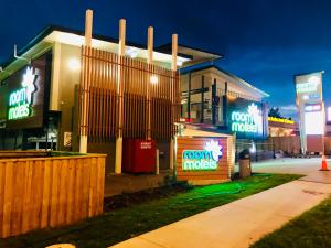 a building with neon signs in front of it at Room Motels Gympie in Gympie