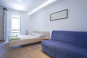 a living room with a blue couch and a table at Studio apartment - seaview in Premantura