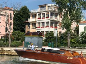 un hombre en un barco en el agua al lado de un edificio en Oasis Lagoon Estate en Venice-Lido