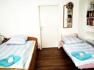 two beds in a small room with a door at Business Apartment VAT Invoice Near Metro in Munich