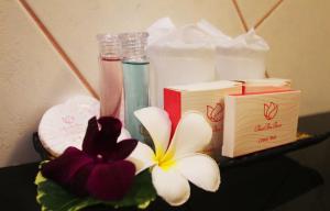 a table with a flower and two bottles of soap at Baan Boa Resort in Patong Beach