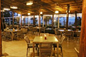 a restaurant with tables and chairs and a view of the ocean at Montego Bay Beach Village - Morjim in Morjim