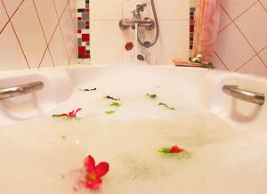 a bath tub filled with water with flowers in it at Baan Boa Resort in Patong Beach
