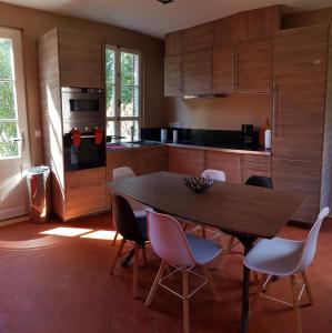 Il comprend une cuisine avec une table et des chaises en bois. dans l'établissement Manoir du Chambellan, à Arnières-sur-Iton